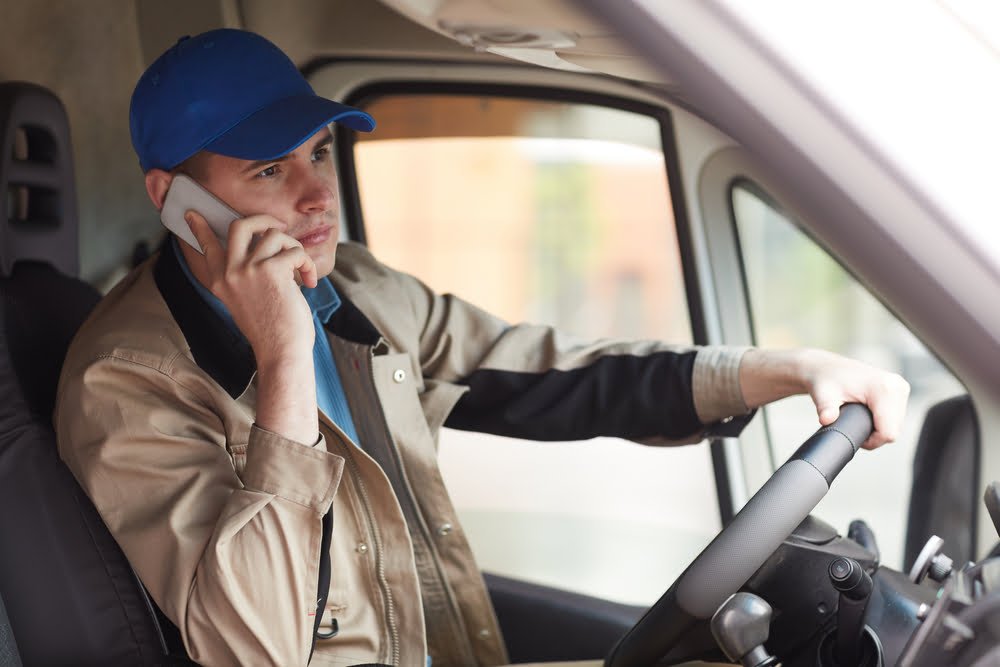 Fleet driver taking on phone while driving a van